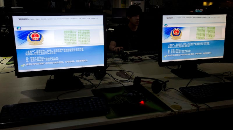 一名中国男子在网吧上网,电脑上显示着中国警方进行网络审查的信息。(美联社)