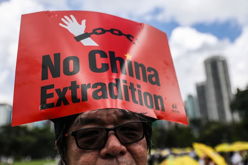 2019年6月9日,香港百万人游行反对特区政府修订《逃犯条例》,示威群众头顶着“不要引渡到中国”标语。(法新社)