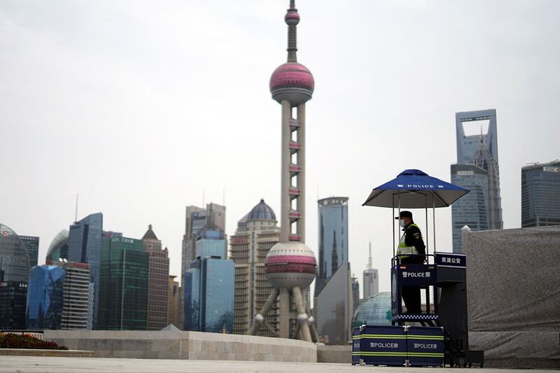 2022 年 3 月 28 日,上海浦东地区采取封锁措施,一名安保人员在黄浦江对岸陆家嘴金融区的建筑物前站岗。(路透社)