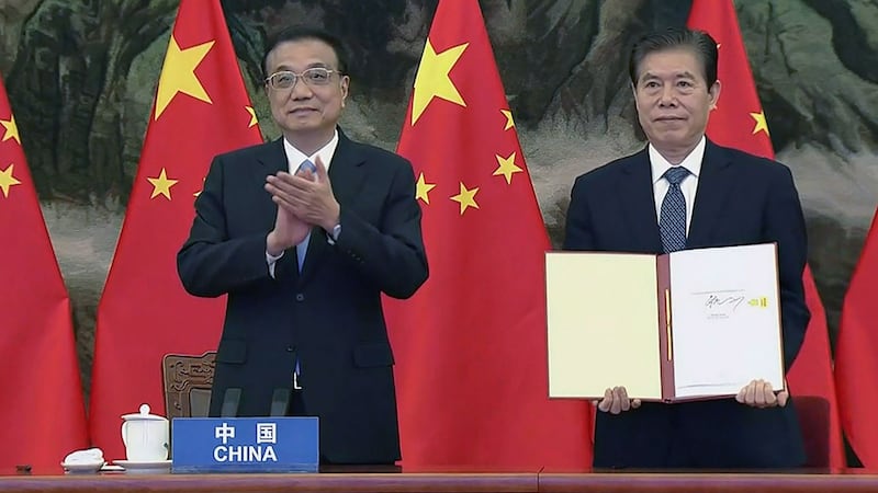 2020年11月15日,中国总理李克强(左)和中国商务部长钟山代表(右)在区域全面经济合作伙伴关系(RCEP)签字仪式上东盟峰会上签署贸易协定。(AFP)