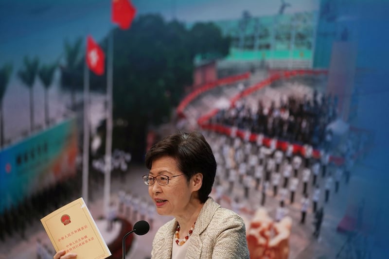 林郑月娥在新闻发布会上发表讲话时手拿香港基本法。(路透社)