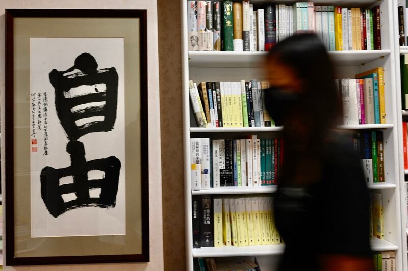 资料图:35 岁的香港护士、曾在 2019 年参加香港反送中抗议活动,走过铜锣湾书局书店展示“自由”的书法。(法新社)