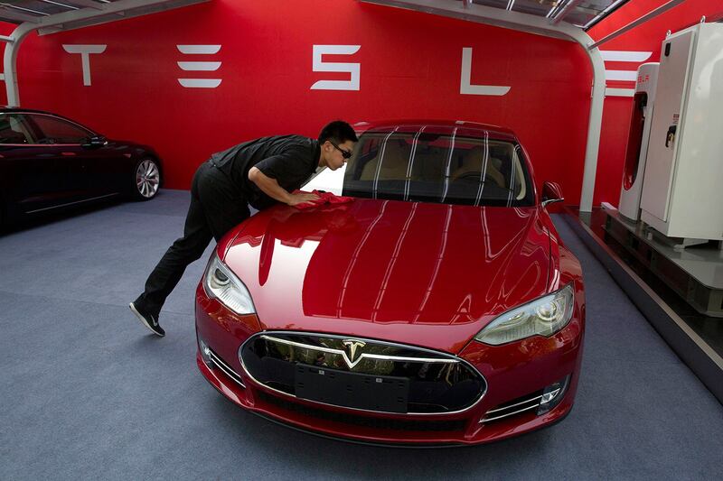 图为,在北京一名工人清洁特斯拉Model S轿车,然后才向客户交付第一批汽车。 (美联社)