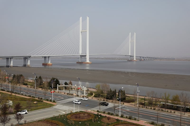 车辆行经辽宁省丹东市新鸭绿江大桥附近的公路,此桥联结了中国的丹东市与朝鲜的新義州市。(路透社资料图片)