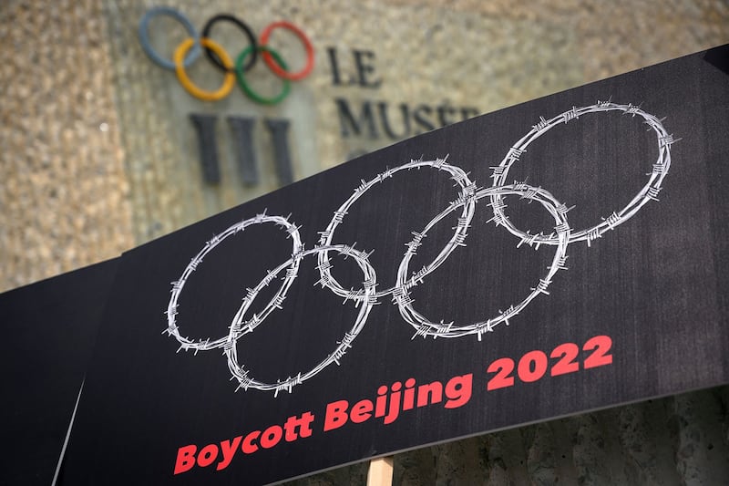奥林匹克博物馆外，活动人士举着扺制2022北京冬奥标语牌。（法新社）