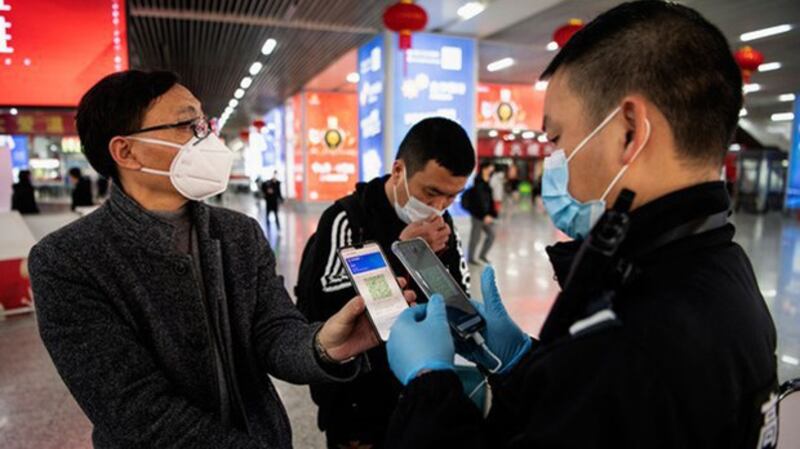 新冠肺炎爆发后中国推出了健康码,民众通过微信或支付宝申请获取,并用其作为出入各地的凭证。图为一名男子正在出示健康码。(法新社)