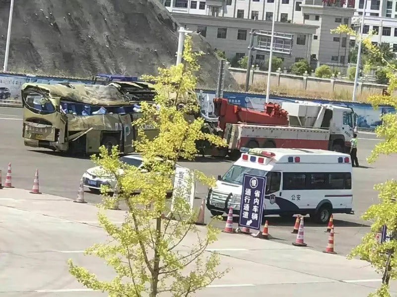 贵阳市一辆运送居民前往隔离的大巴翻入深沟,造成27死,20伤,翻覆的大巴明显变型。(微博)