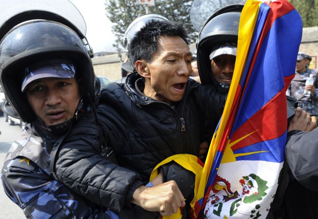 བལ་ཡུལ་གྱི་རྒྱ་ནག་གཞུང་ཚབ་མདུན་ངོ་རྒོལ་བྱེད་མཁན་ཉེན་རྟོག་པས་འཇུ་བཟུང་བྱེད་བཞིན་པ། ༢༠༡༤།༣།༡༠
