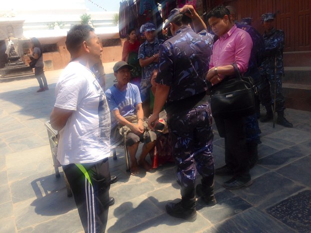 བོད་ཅེས་བྲིས་བའི་གྱོན་ཆས་གྱོན་དང་། ང་བོད་ལ་དགའ་ཅེས་བྲིས་བའི་རྒྱབ་ཁུག་ཡོད་མཁན་ཡོད་མི་གཉིས་ལ་ཉེན་རྟོག་པ་འདྲི་རྩད་བྱེད་བཞིན་པ། ༢༠༡༤།༤།༢༥