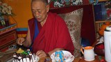 སྨན་རི་ཁྲི་འཛིན་མཆོག་གིས་འཁྲུངས་སྐར་རྟེན་འབྲེལ་གྱི་མངར་ཟས་གཏུབ་བཞིན་པ། 