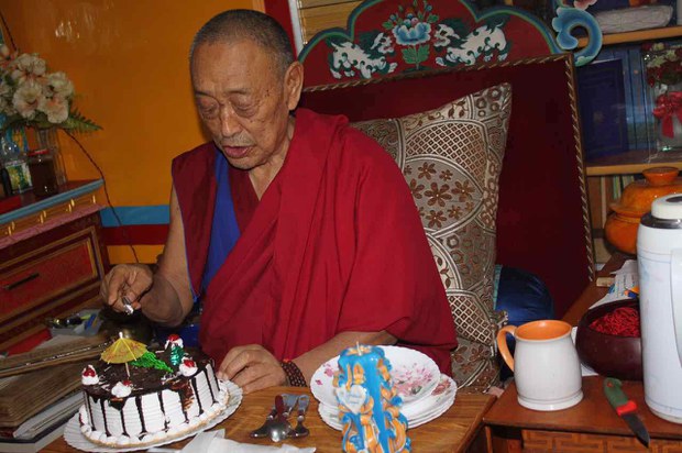 སྨན་རི་ཁྲི་འཛིན་མཆོག་གིས་འཁྲུངས་སྐར་རྟེན་འབྲེལ་གྱི་མངར་ཟས་གཏུབ་བཞིན་པ། 
